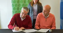 Dos personas firmando un acuerdo de cooperación