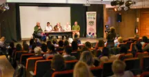 Público escuchando al panel de la mesa de apertura del evento 