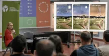 Persona exponiendo junto a una pantalla  