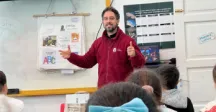 Integrante de la Dirección de Turismo dando una charla en un salón de clases 