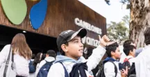 Niño saludando en la puerta del stand de Canelones