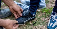 Niño calzandose un zapato de fútbol 